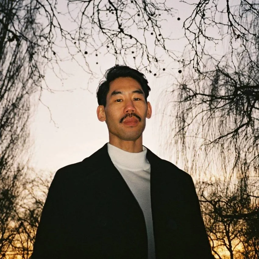 Hunee promotional portrait outdoors beneath trees