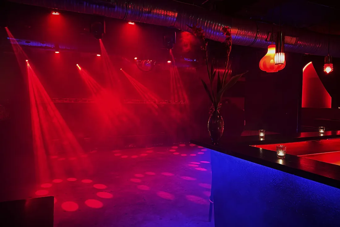 Beate Uwe empty dancefloor under red beams beside the bar