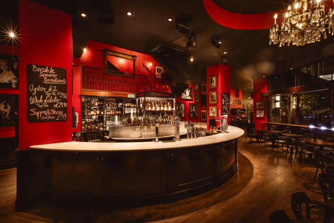Boisdale of Canary Wharf round central bar under chandelier, red walls