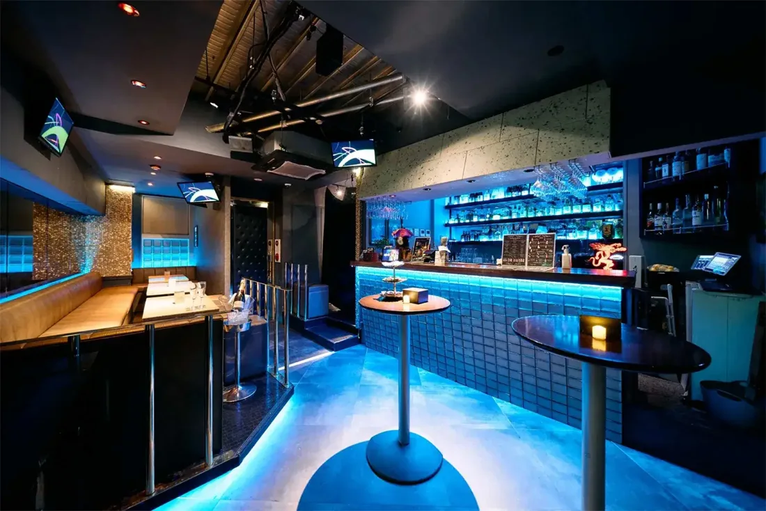 BRAND SHIBUYA blue-lit bar counter, booth seating and high tables
