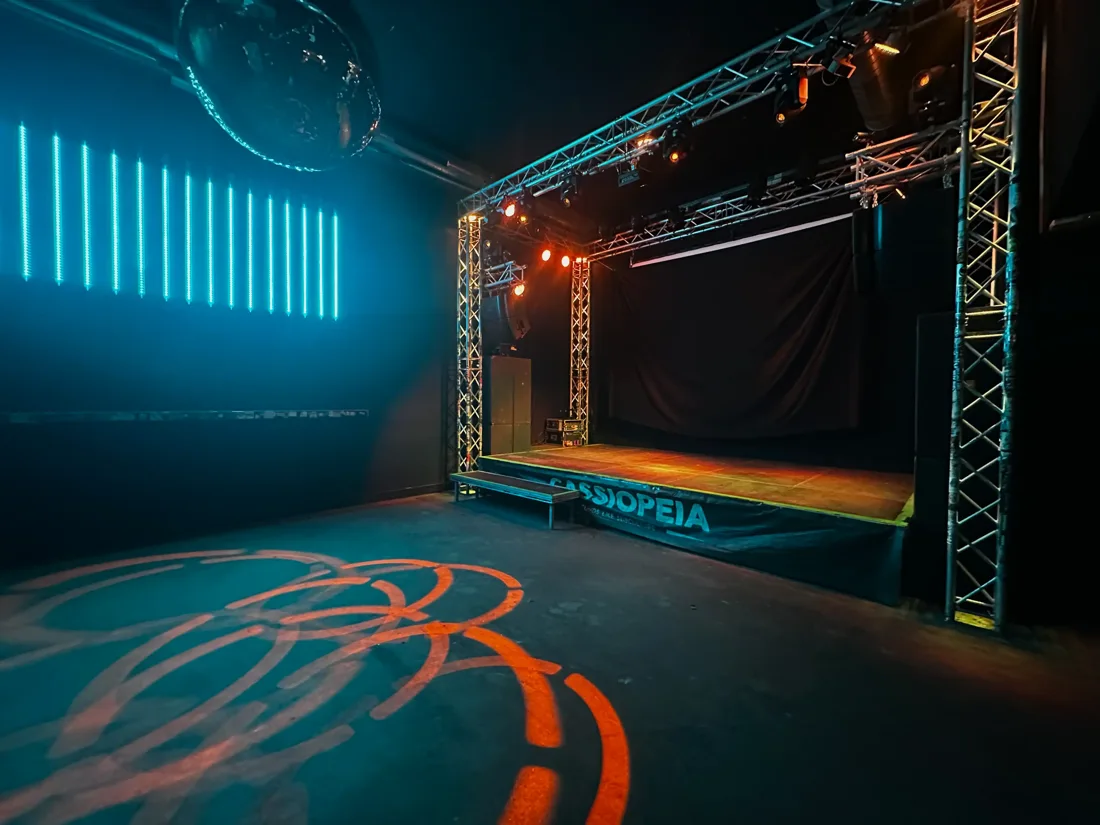 Cassiopeia back-room stage under truss lights with the Cassiopeia banner