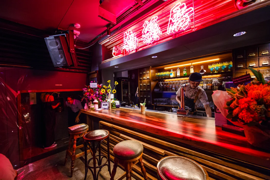 Débris bar counter with red neon sign and stools