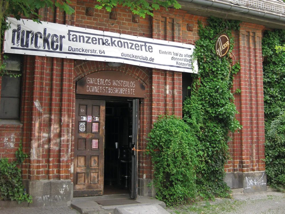 Dunckerclub brick entrance with ivy and Dunckerstr. 64 banner