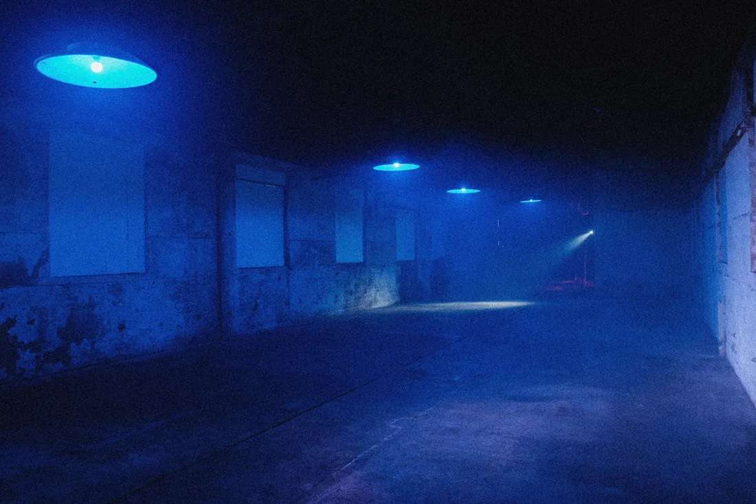 Electrowerkz Warehouse room: empty hazy concrete space under blue pendant lamps