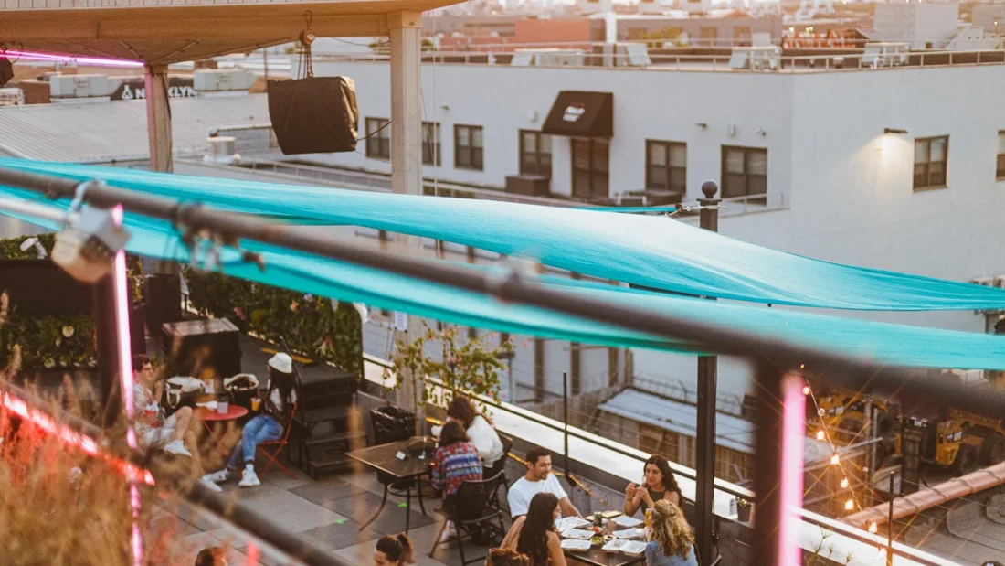 Elsewhere rooftop terrace with teal awnings and diners over Bushwick