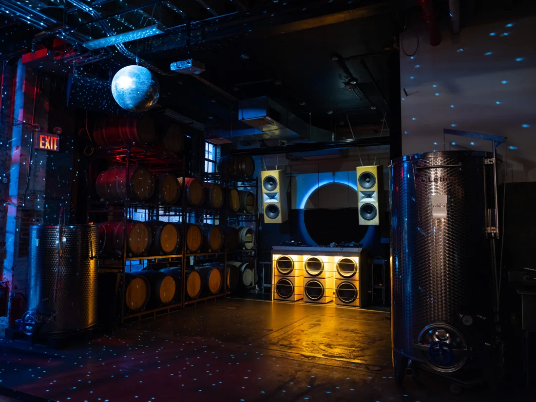 Honey's winery room with disco ball, wine barrels and lit speaker stack