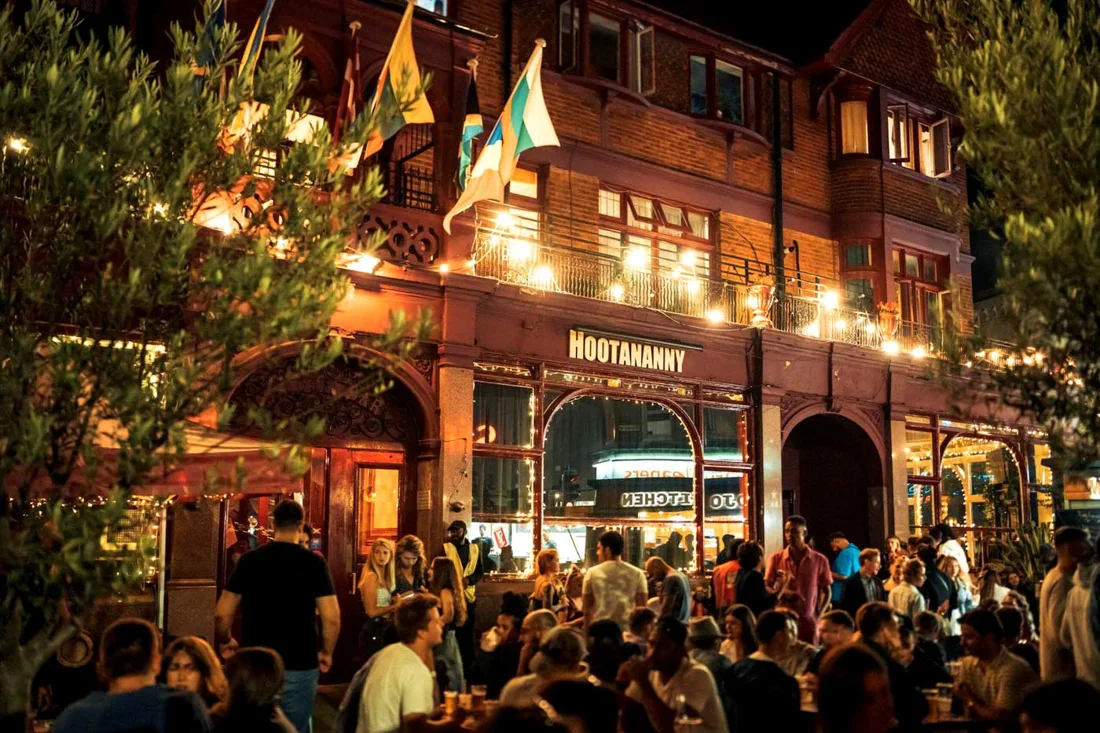 Hootananny Brixton building at night with HOOTANANNY sign and busy terrace