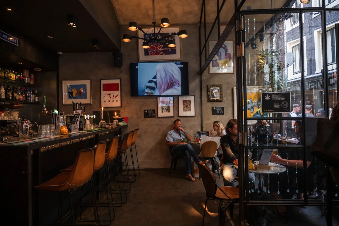 Kadinsky Cafe bar with stools, framed art and glass door onto the alley