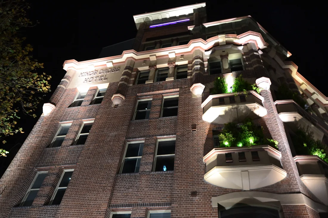 Kings Cross Hotel red-brick facade at night with name on the parapet