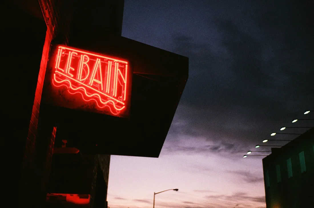 Le Bain red neon sign on the building at dusk
