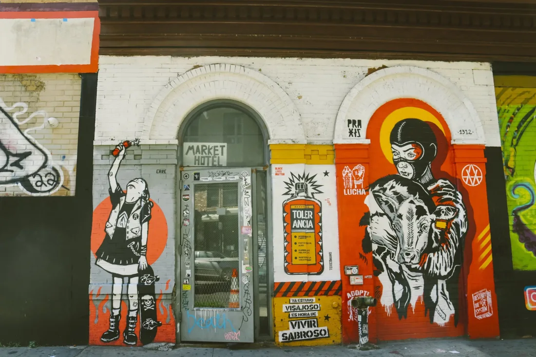 Market Hotel street entrance with door sign among murals