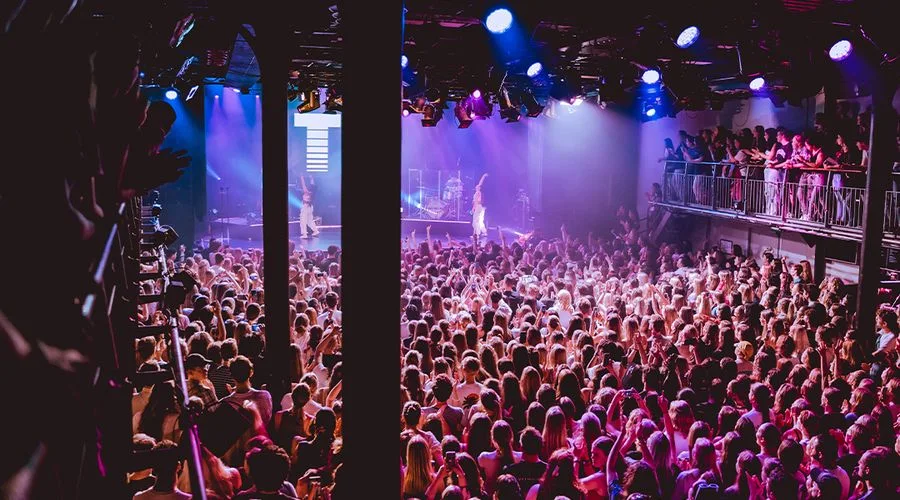 A live concert crowd, performers and balcony audience inside Melkweg