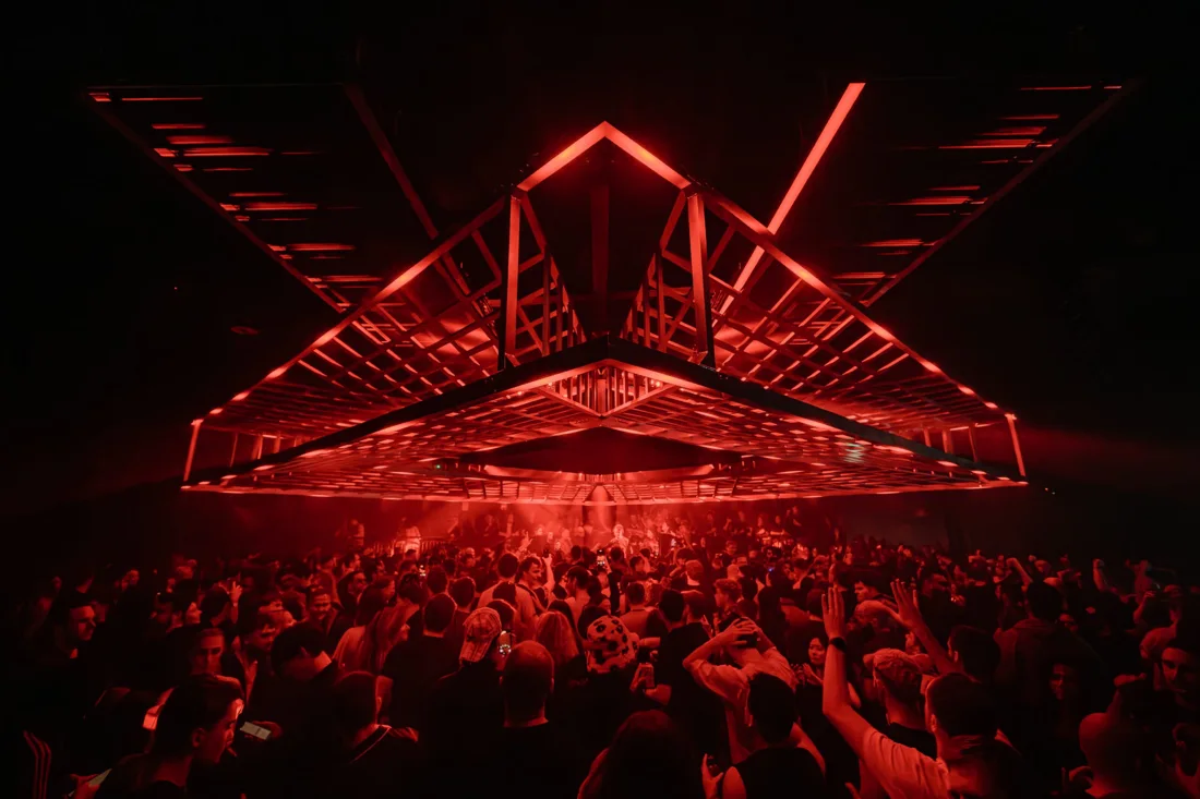 A packed dancefloor beneath red lighting at Ministry of Sound, London