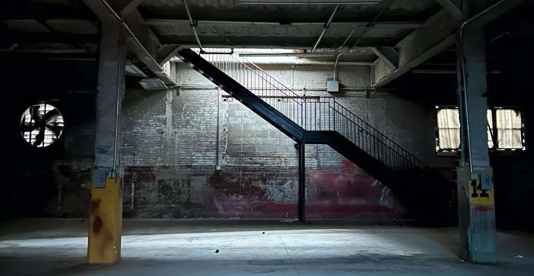Qncc empty warehouse floor with brick wall and steel staircase