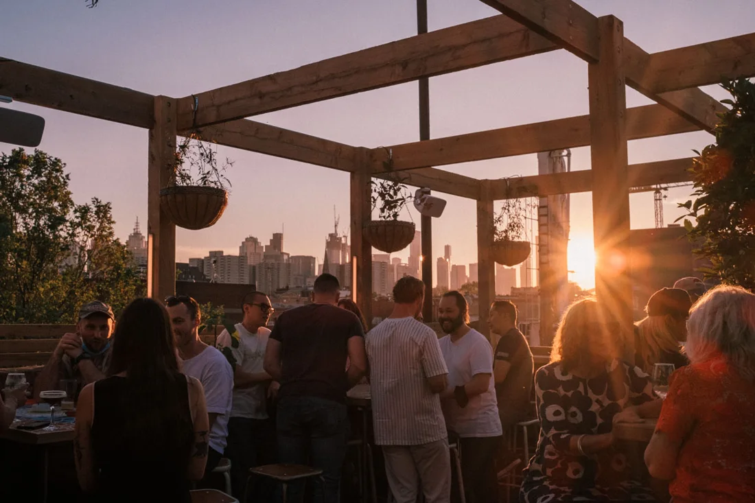 Runner Up timber-pergola rooftop at sunset with the city skyline
