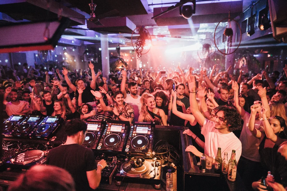 A DJ playing to a crowded dancefloor inside Shelter in Amsterdam