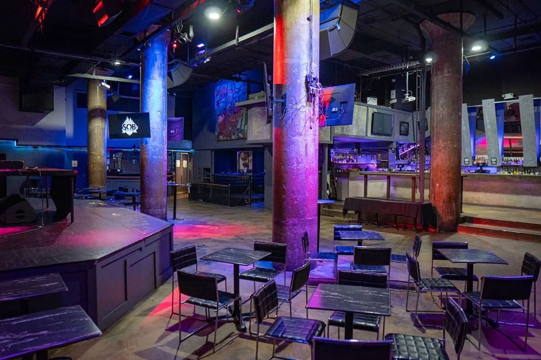 SOBs empty main room with stage, pillars, tables and bar