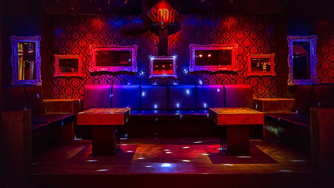 Soda Club lounge booths with red damask walls, mirrors and SODA sign