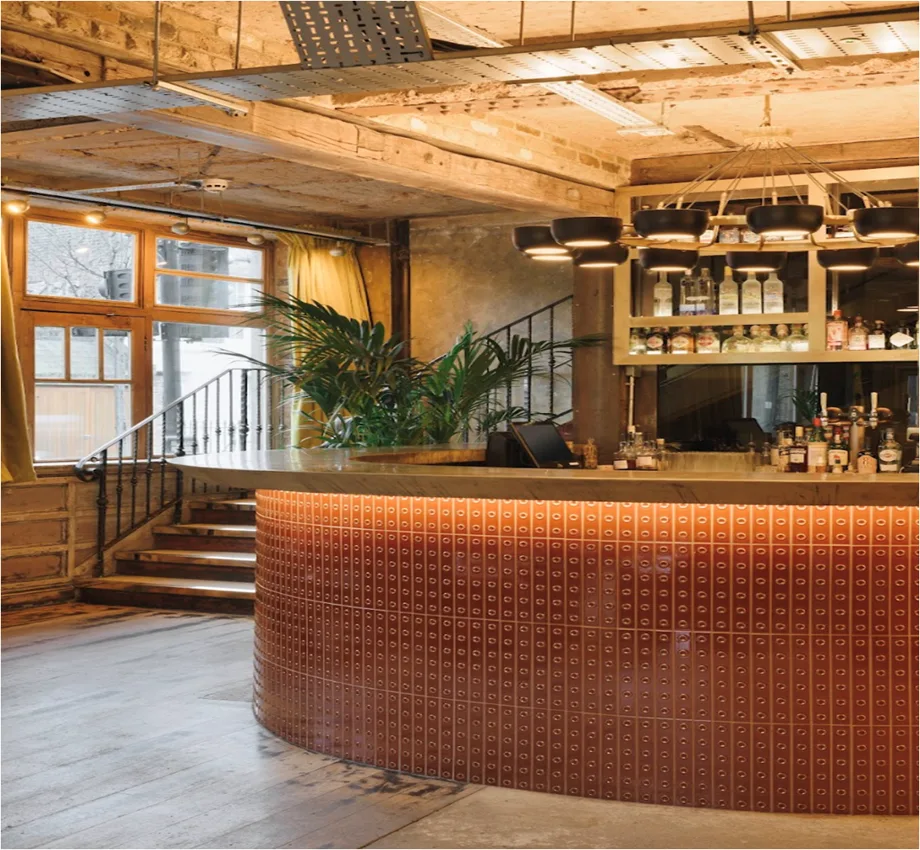 The Cross ground-floor cocktail bar with curved tiled counter and timber ceiling