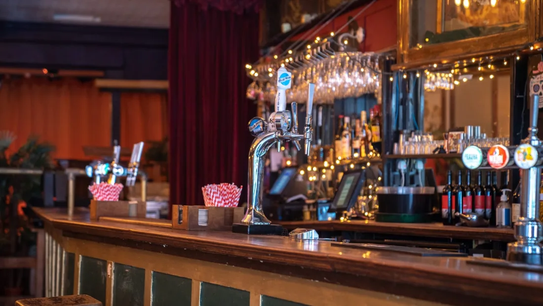 The Fox and Firkin wooden bar with taps and velvet curtain