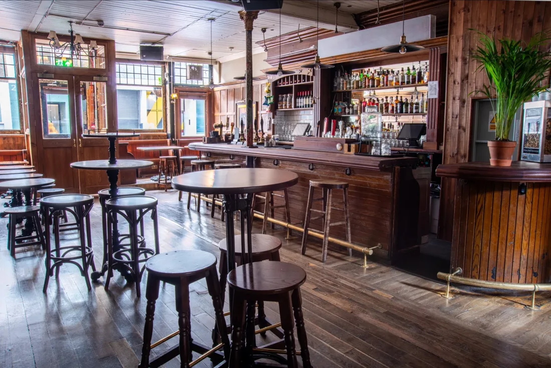 The Horse & Groom wood-panelled bar with high tables and stools