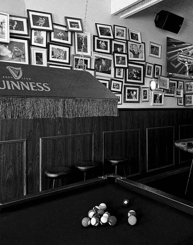 The Lady Hampshire pool table and wall of framed photos, black and white