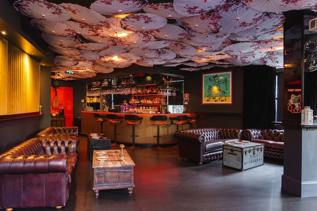 The Lucky Cat lounge under parasol ceiling, curved bar and Chesterfield sofas