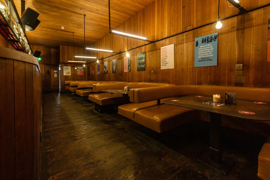 The Social upstairs bar with wood panelling and leather booths