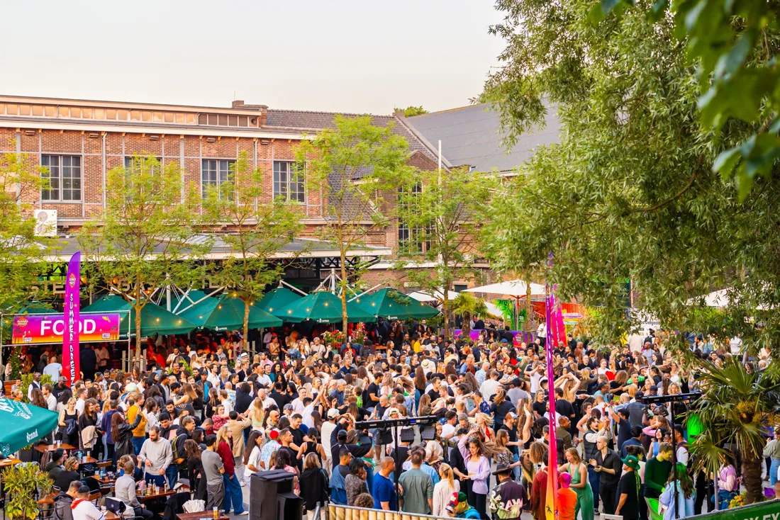 WestWeelde terrace crowd at a summer party, brick Westergas building behind